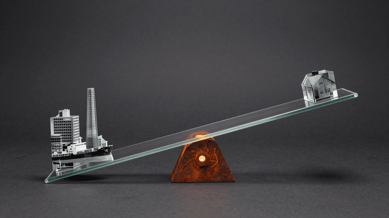 Seesaw in glass style: a clear glass beam on a rusted base against a dark background.